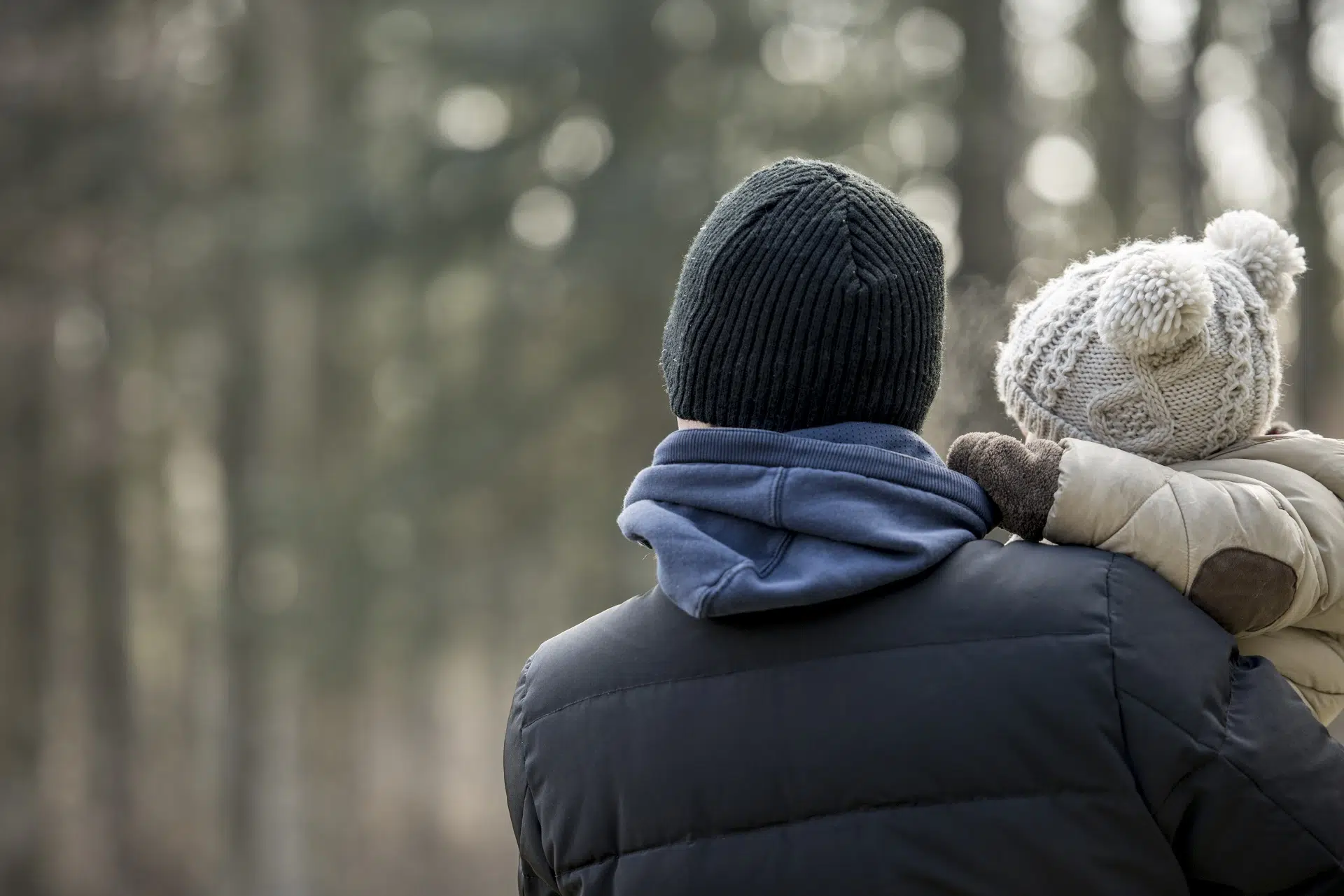 Father carrying child in winter clothing outdoors