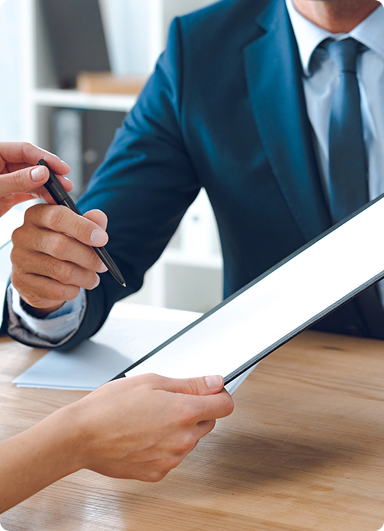 two individuals engaged in a business interaction where a contract or official document is being signed two individuals engaged in a business interaction where a contract or official document is being signed