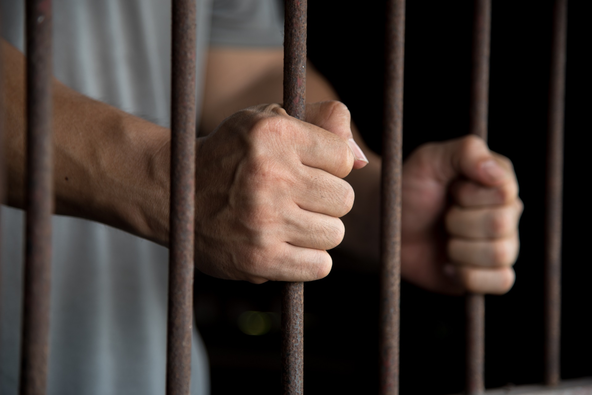 Hands of the Prisoner in Jail | Drug Charges Attorney​​ in Los Angeles California | Wegman & Levin
