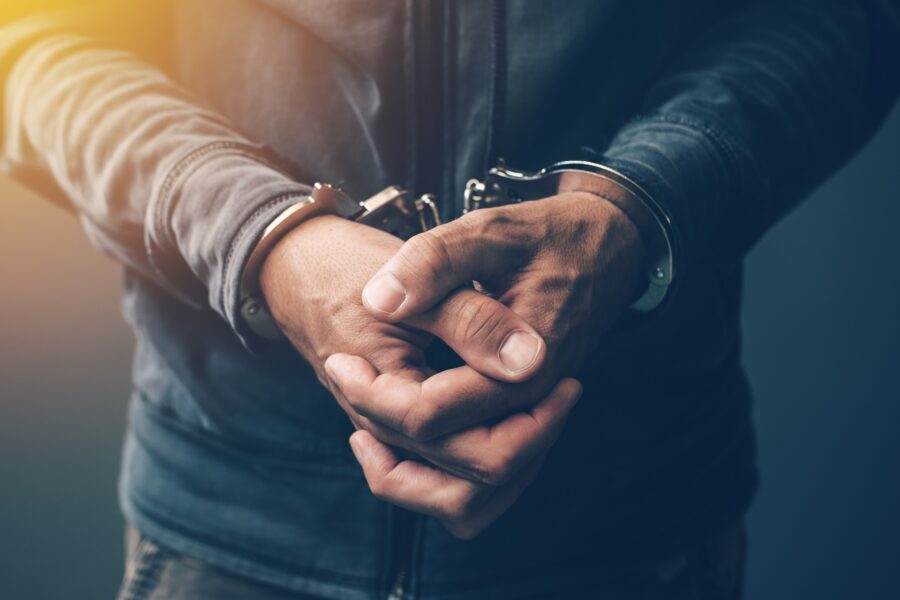 A man in handcuffs holding hand | Drug Charges Lawyer | Wegman & Levin