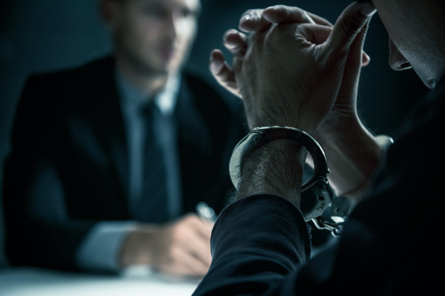 Man with Handcuffs in Interrogation Room with Police | Criminal Attorney in LA | Wegman & Levin