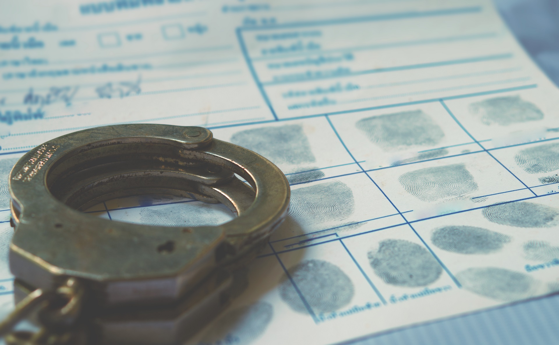 A pair of handcuffs and a fingerprint on a paper | DUI Homicide Defense Lawyer | Wegman & Levin