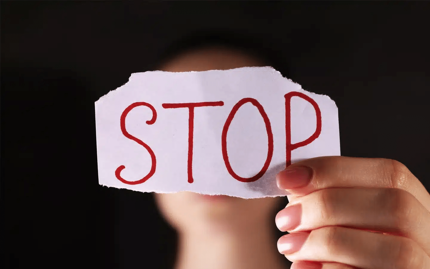 Woman Holding Piece of Paper with Word Stop | Criminal Defense Attorney in LA | Wegman & Levin